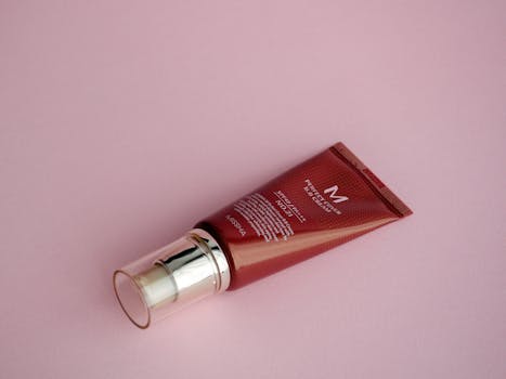 Close-up of a cosmetic tube on a pink surface, perfect for skincare and beauty themes.