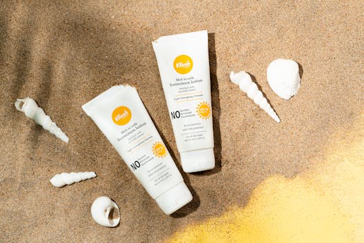 Two sunscreen lotion tubes on sandy beach alongside seashells for sun protection imagery.
