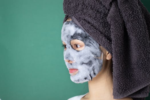 Side view of a woman wearing a bubble sheet mask and towel wrap for skincare in a spa setting.