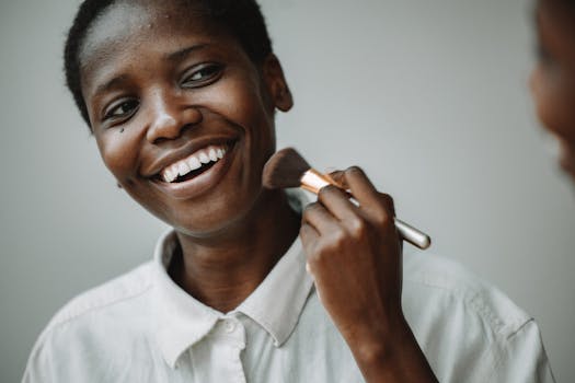 Close-up of a cheerful woman applying makeup with a brush. Perfect for beauty and lifestyle themes.
