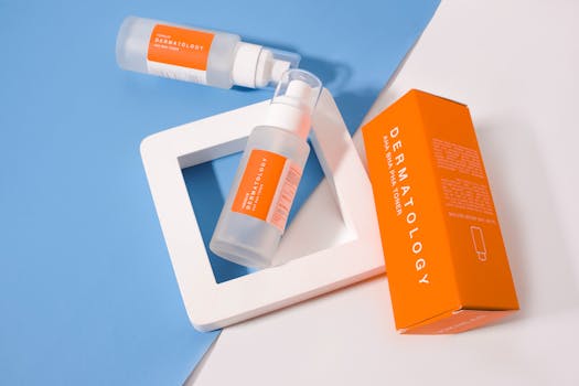 Stylish presentation of dermatology skincare products with orange packaging on a geometric background.