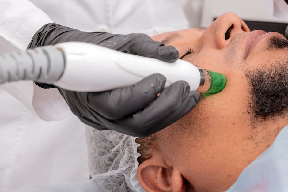 A close-up of a man receiving a professional skincare treatment in a clinical setting.