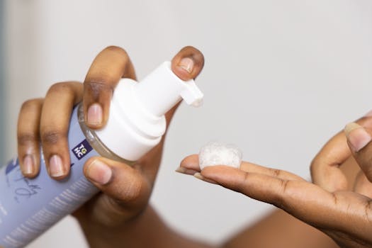 Close-up of hands dispensing soothing foaming face wash, ideal for sensitive skin care.