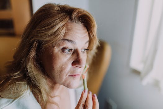 A woman applying a skincare product indoors, focusing on relaxation and self-care.